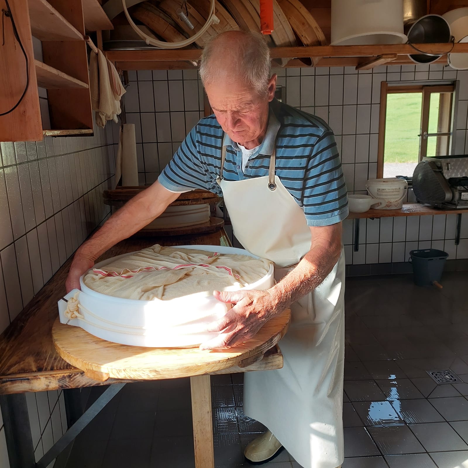 Norbert Wirth richtet den jungen Käse in der Form zum Pressen her